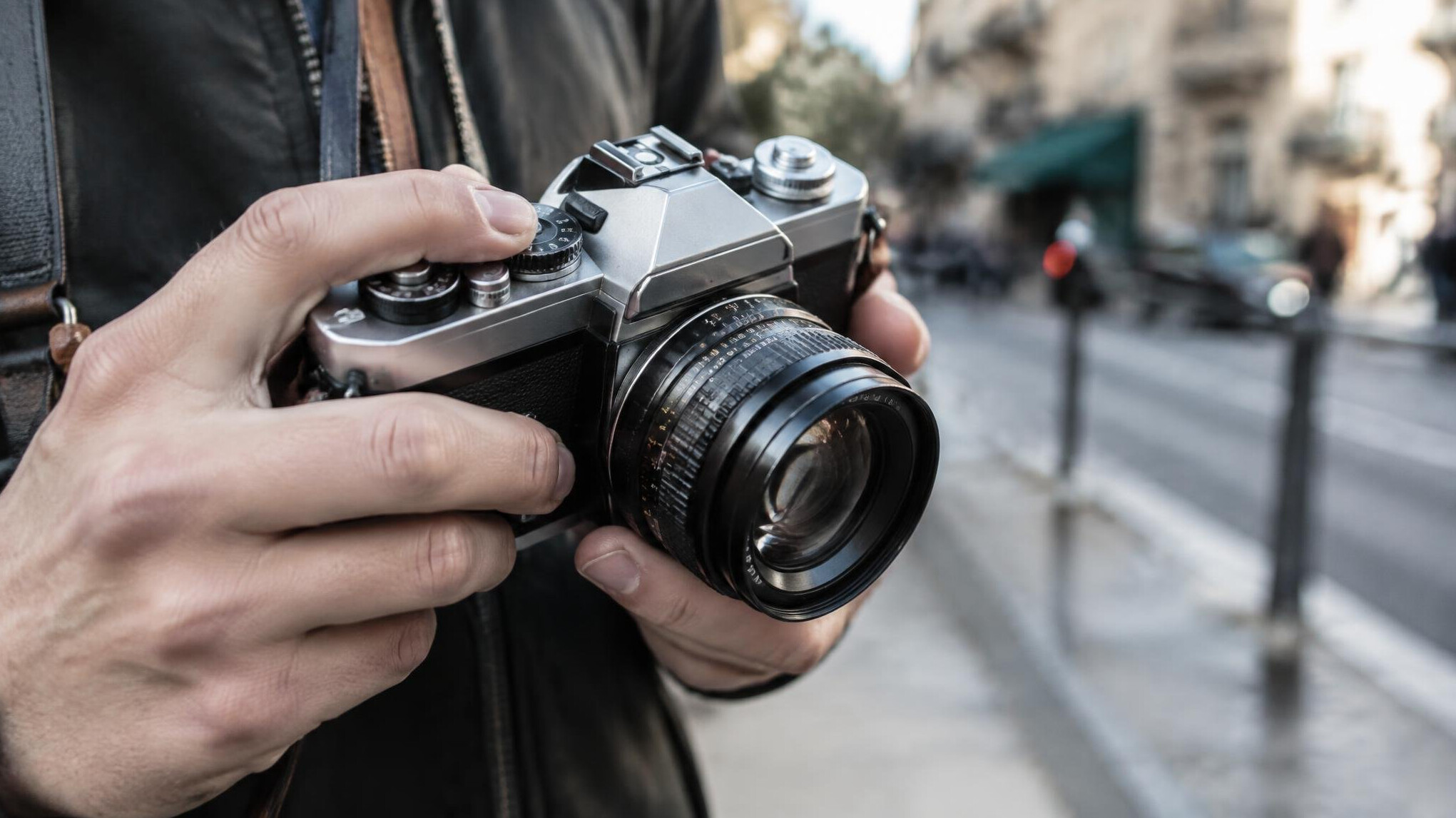 Close up of a vintage camera lens held by a photographer